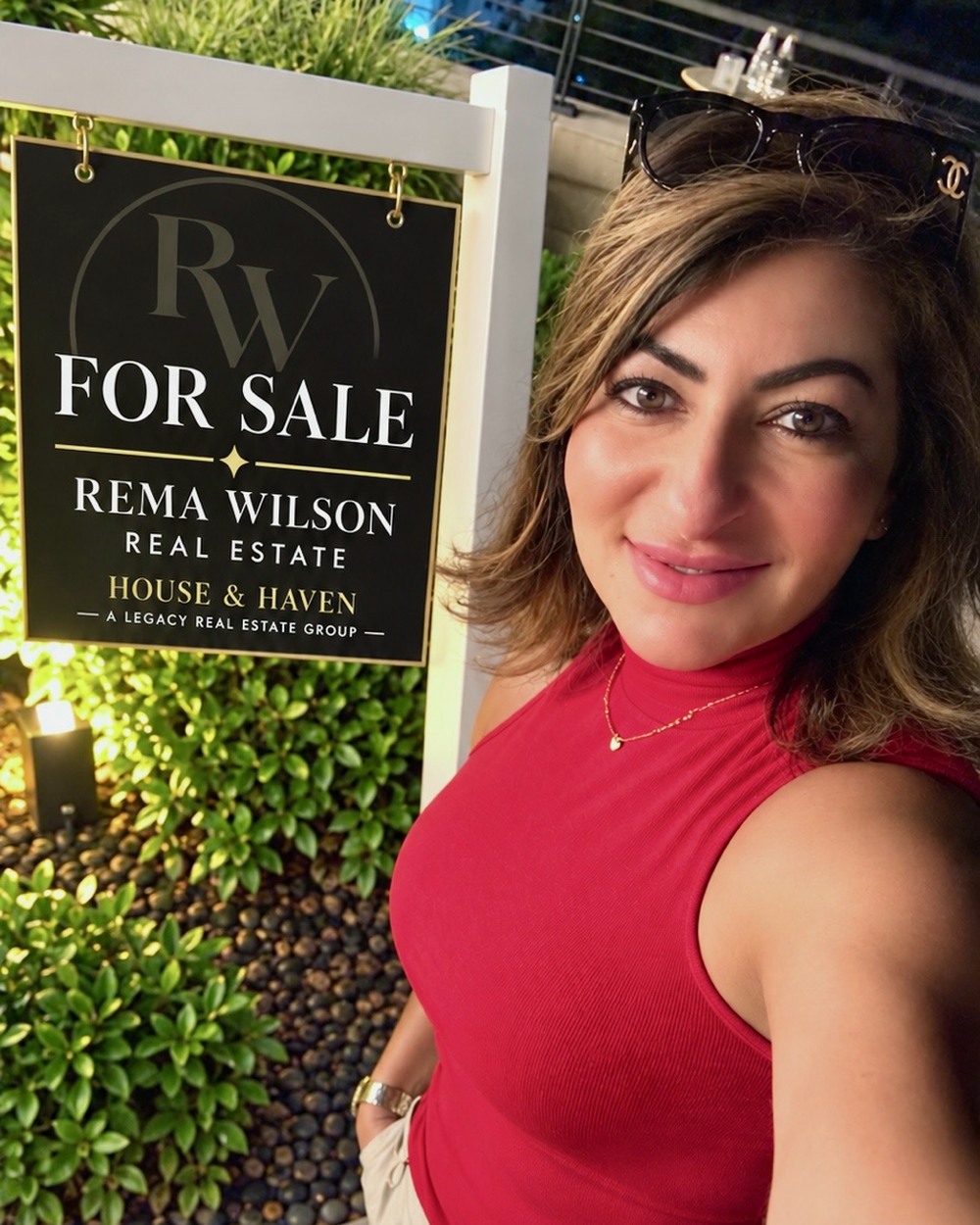 Rema Wilson beside one of her own For Sale signs